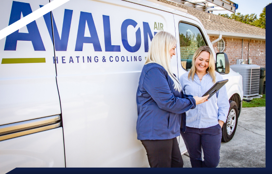 an avalon work van is parked behind an hvac technician that is reviewing something with a customer on a tablet
